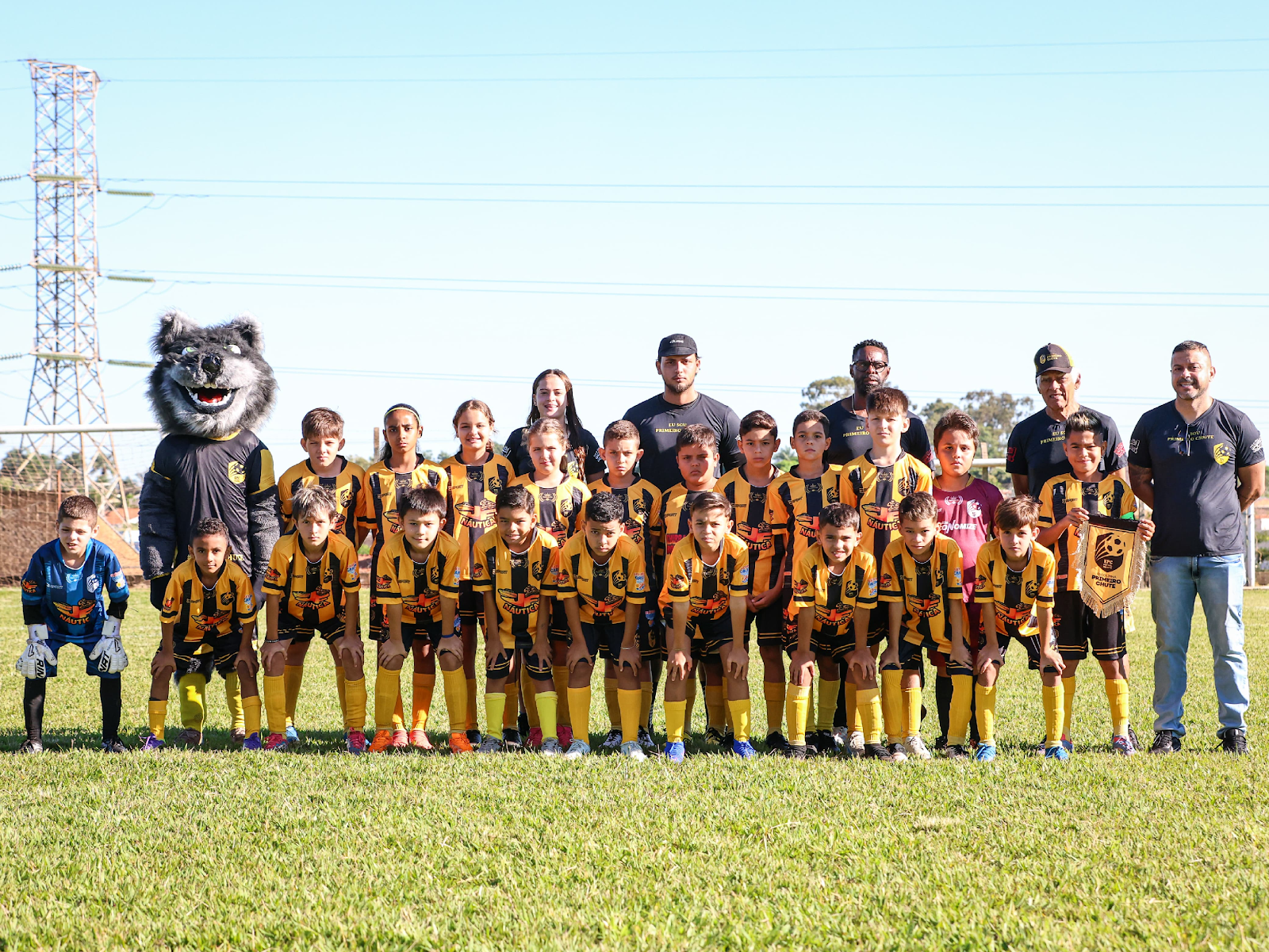 Grupo de pessoas na grama posando para fotoDescri&ccedil;&atilde;o gerada automaticamente